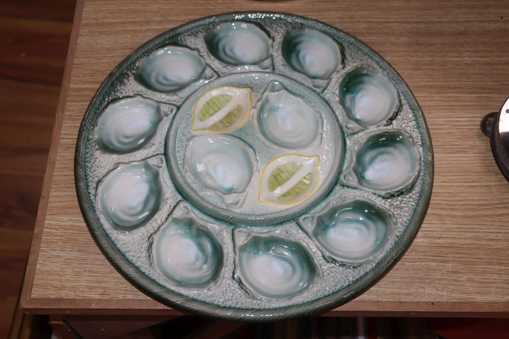 A set of four pottery oyster dishes, and a platter, the platter diameter 37cm